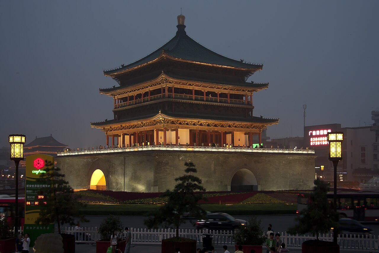 The illuminated Bell Tower in Xi’an, with traditional tiled roofs and stone base at dusk.